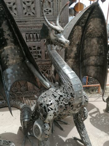 Sculpture dragon métal recyclé Smaug – profil ailes déployées et griffes